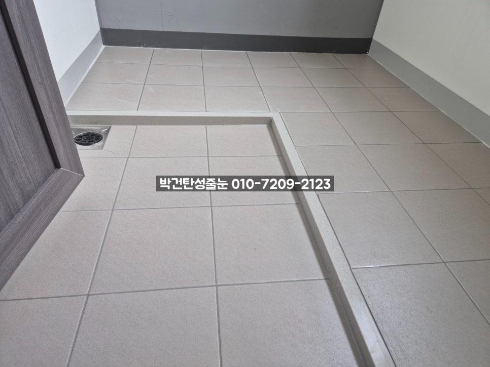 베이지색 타일 바닥과 배수구가 설치된 복도 공간