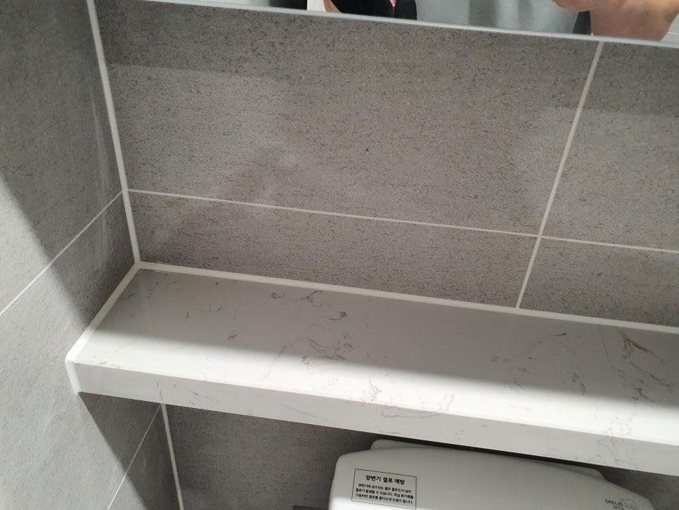 회색 타일 벽면과 흰색 마블 패턴 상판의 디테일