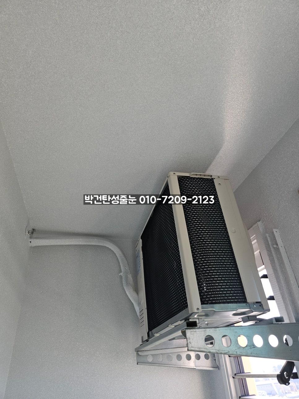 에어컨 외부 유닛과 백색 배관이 설치된 벽면
