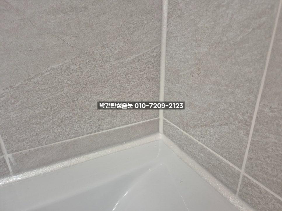 흰색 욕조와 회색 타일 벽면의 코팅 마감