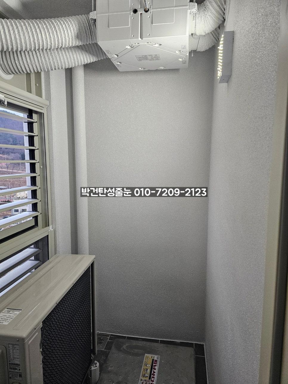 공기순환기와 바닥 타일이 보이는 실외기실 공간
