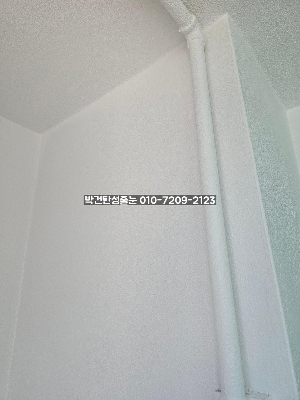 흰색 배관이 노출된 벽면의 일부