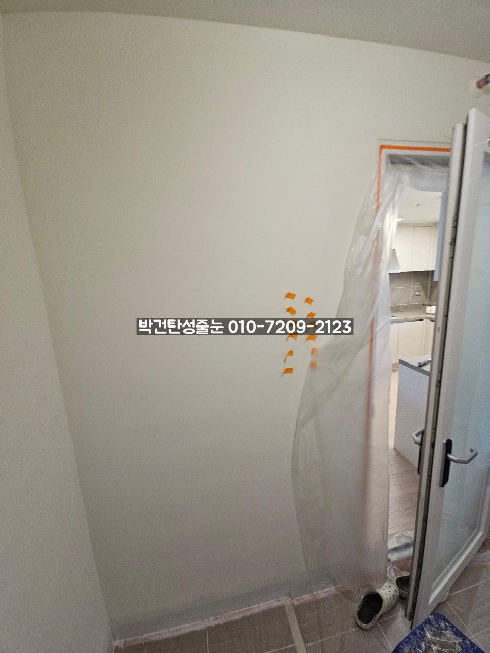 흰색 문 앞에 플라스틱 보호막을 설치한 현관 모습