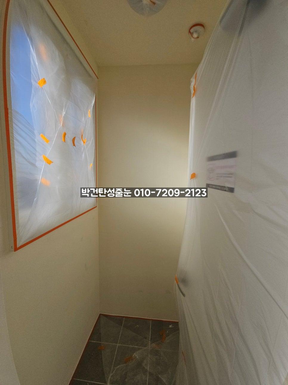 흰색 비닐과 오렌지색 테이프로 덮인 복도 벽면
