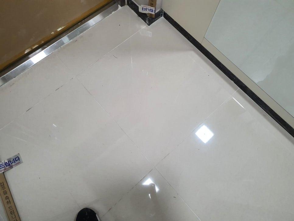 흰색 패널과 검은색 마감선이 보이는 벽면과 바닥