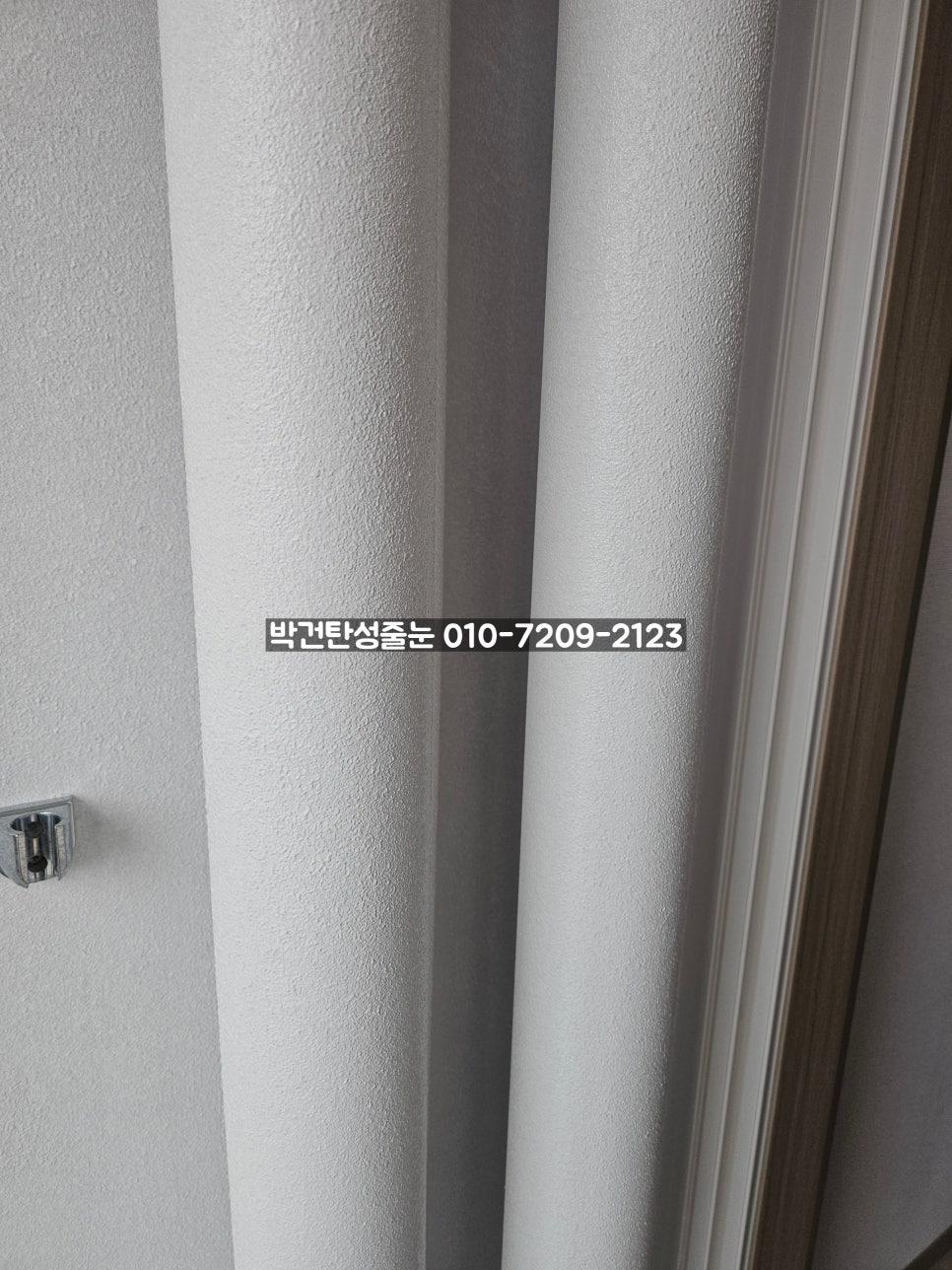 텍스처 마감 벽면과 문틀이 보이는 복도 공간의 모습