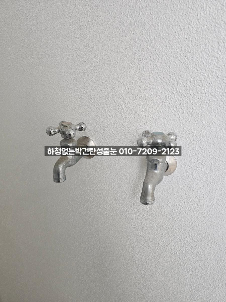 벽면에 부착된 금속 수전의 근접 모습