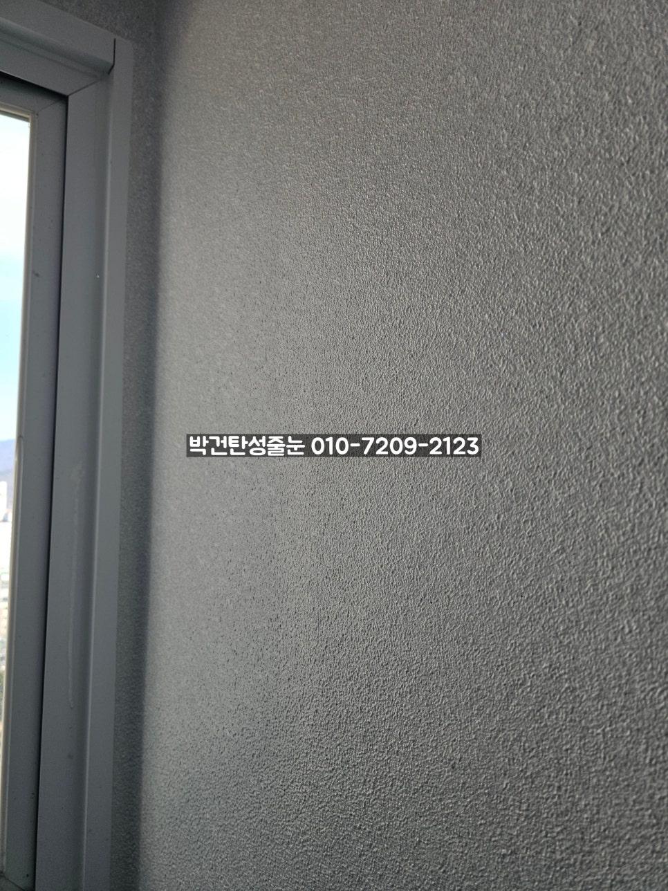 창문 프레임과 맞닿은 회색 텍스처 벽면