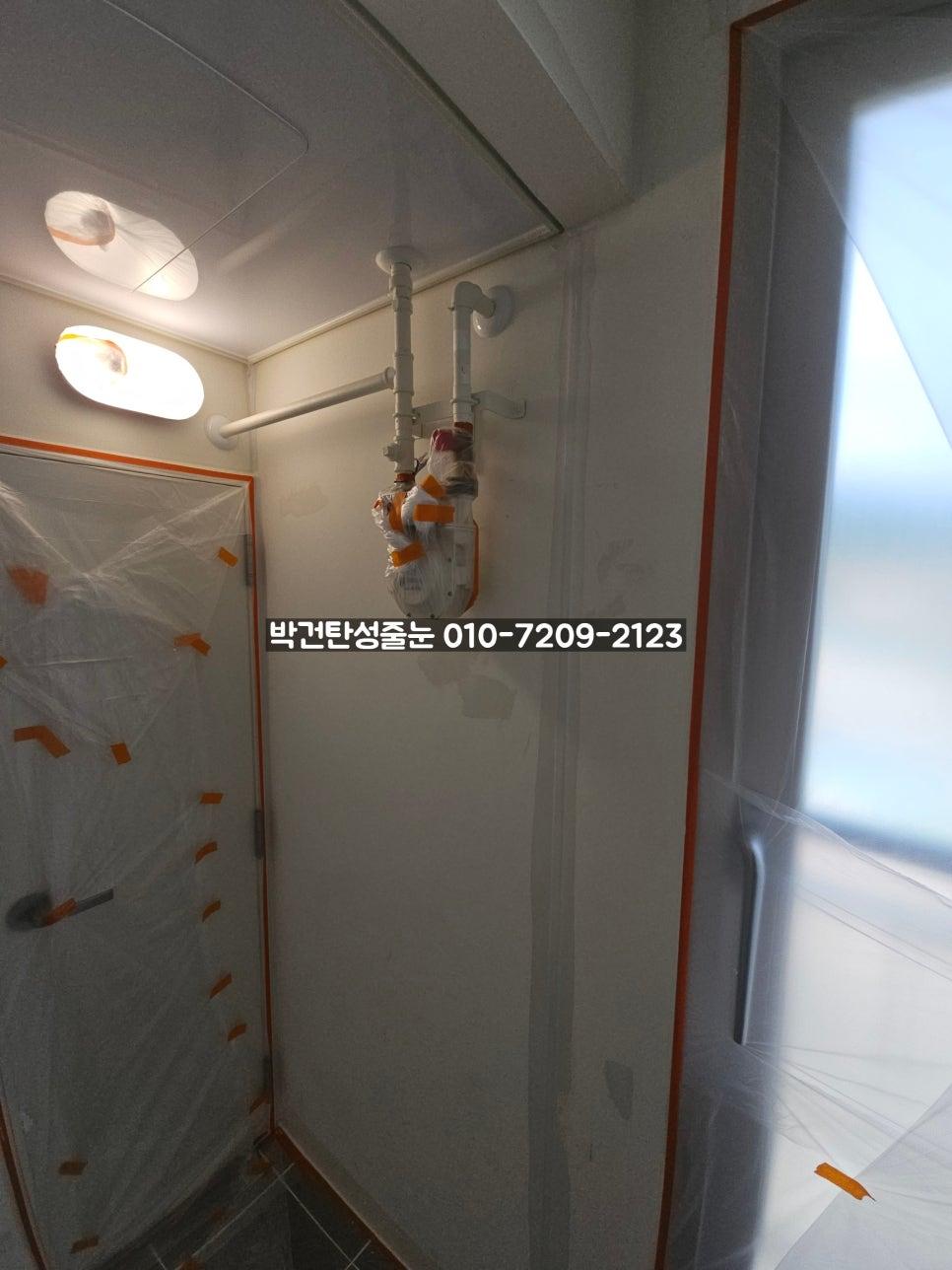 필름으로 덮인 문과 노출 배관이 보이는 복도