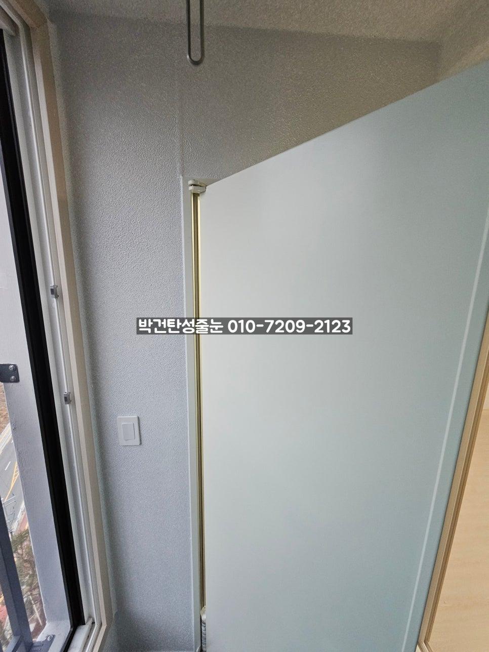 회색 벽면과 금색 프레임 유리 문, 검은 창호의 접합부
