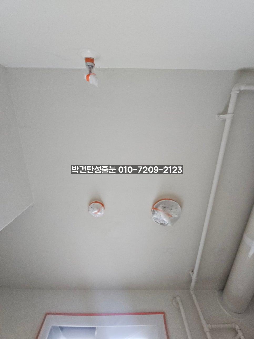 천장 화재 경보기와 배관이 설치된 상단부
