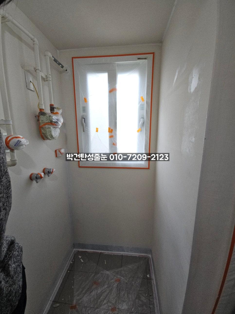 백색 배관과 주황색 테두리가 보이는 복도 벽면
