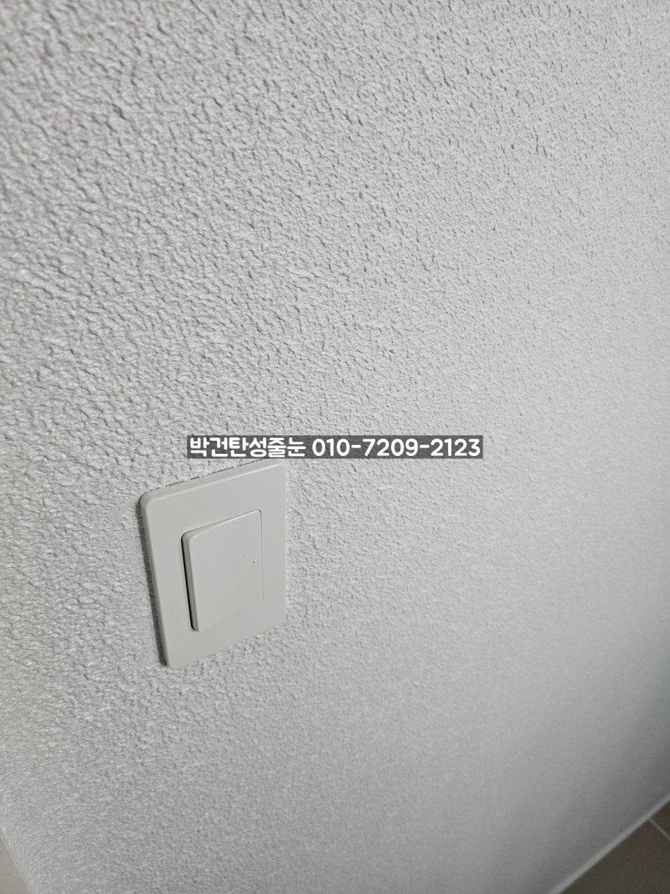 흰색 스위치 플레이트가 설치된 텍스처 벽면