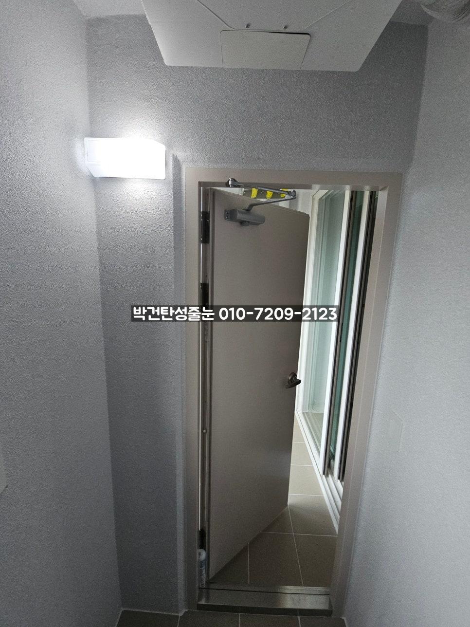 회색 텍스처 벽면과 조명이 보이는 현관 구역