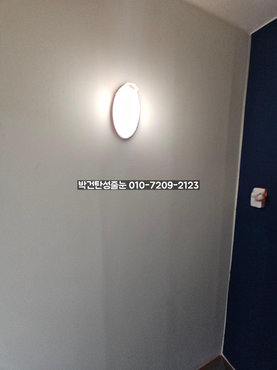 원형 조명과 스위치가 있는 복도 벽면의 보양 상태