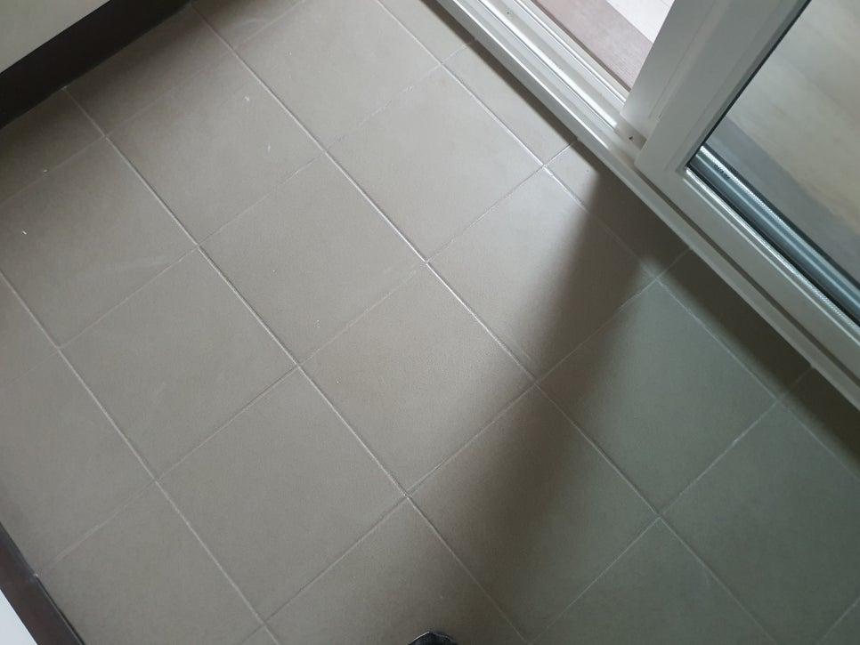 베이지색 타일 바닥과 흰색 창호 프레임의 접합부