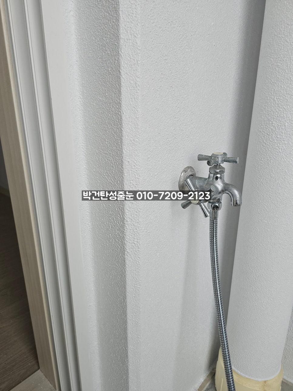 금속 수전과 유연한 호스가 설치된 벽면