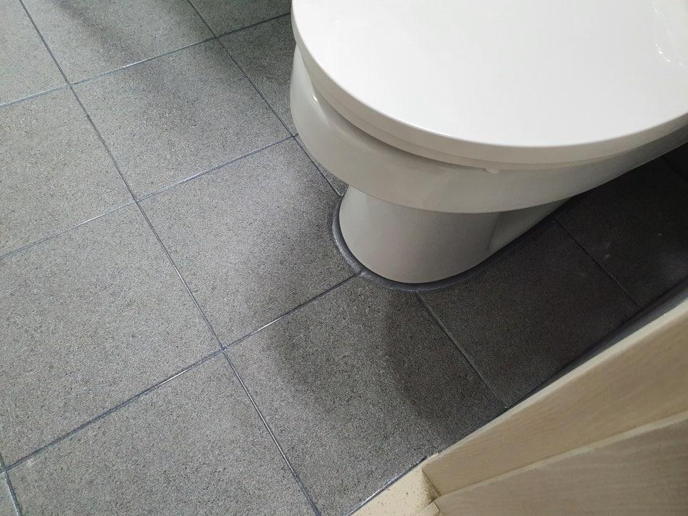 흰색 세면대와 회색 타일 바닥의 접합부 마감