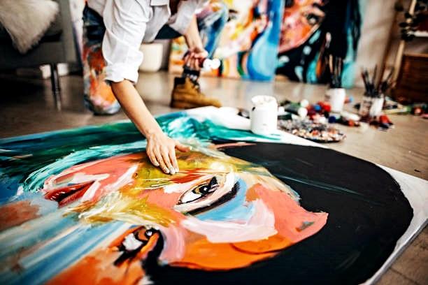 그림 작업을 하는 사람과 주변의 미술 도구들