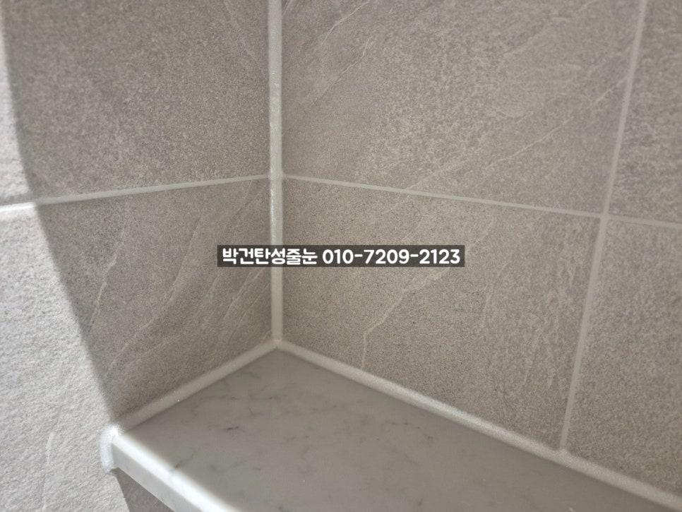 회색 타일 벽면과 흰색 실리콘 마감