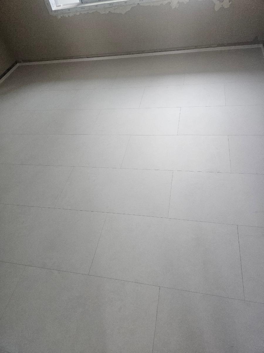 흰색 타일 바닥과 벽, 천장이 보이는 방