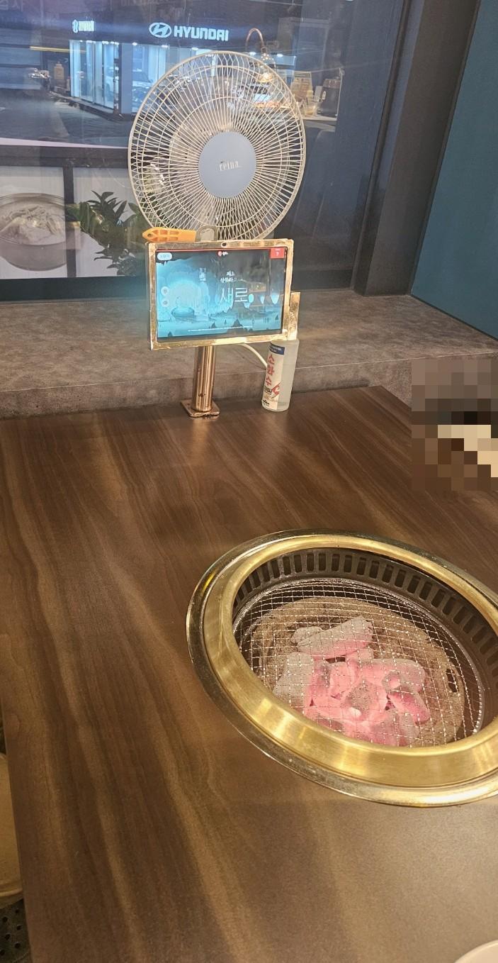 블루 LED 디스플레이와 금색 그릴이 놓인 테이블