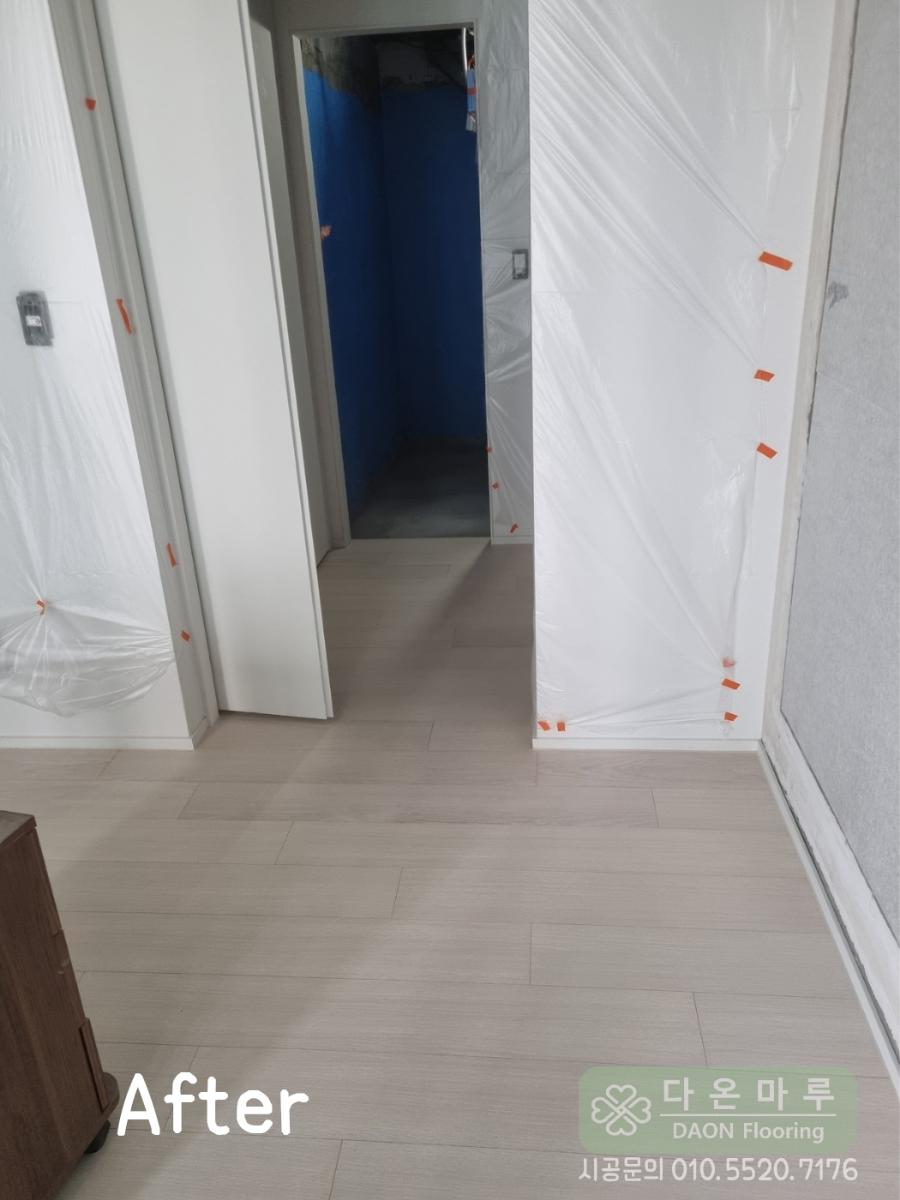 흰색 벽면과 조화를 이루는 복도 바닥 마감