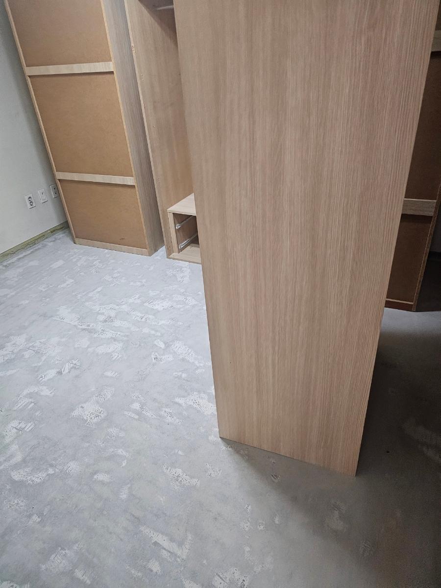 흰색 콘크리트 바닥 위 설치된 목재 수납장