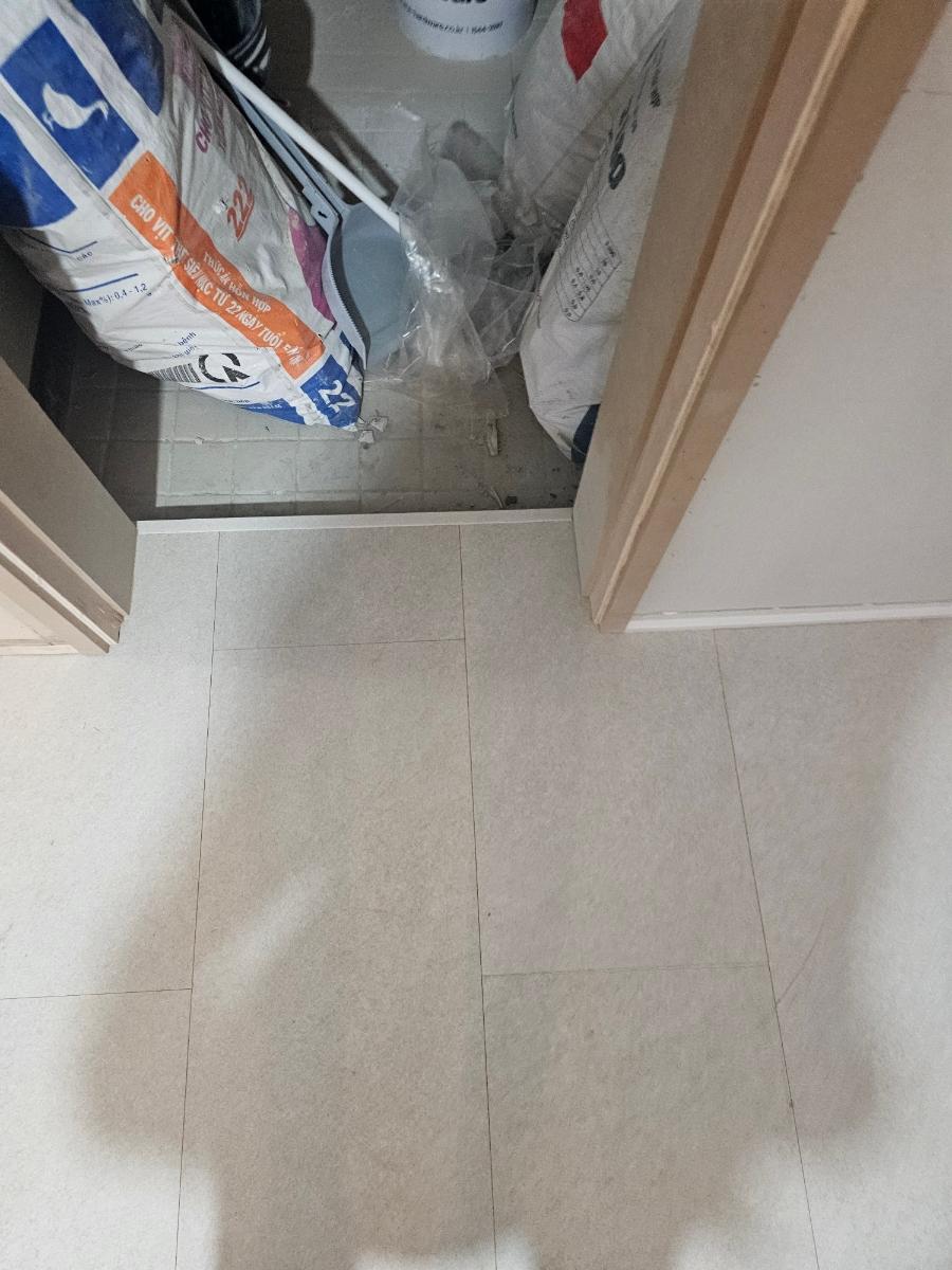타일 시공 후 문 주변에 놓인 자재 포장재들