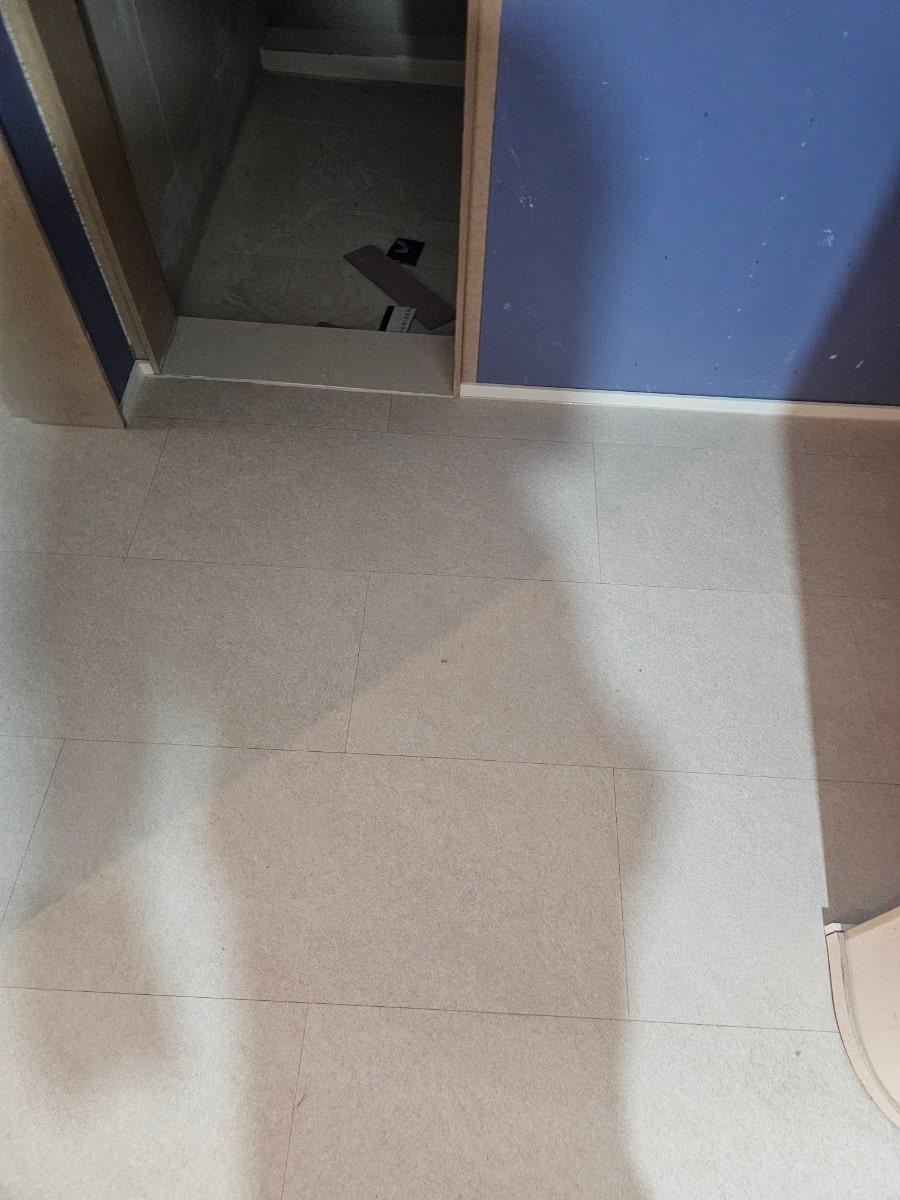 파란색 벽면과 흰색 타일 바닥이 교차하는 문가