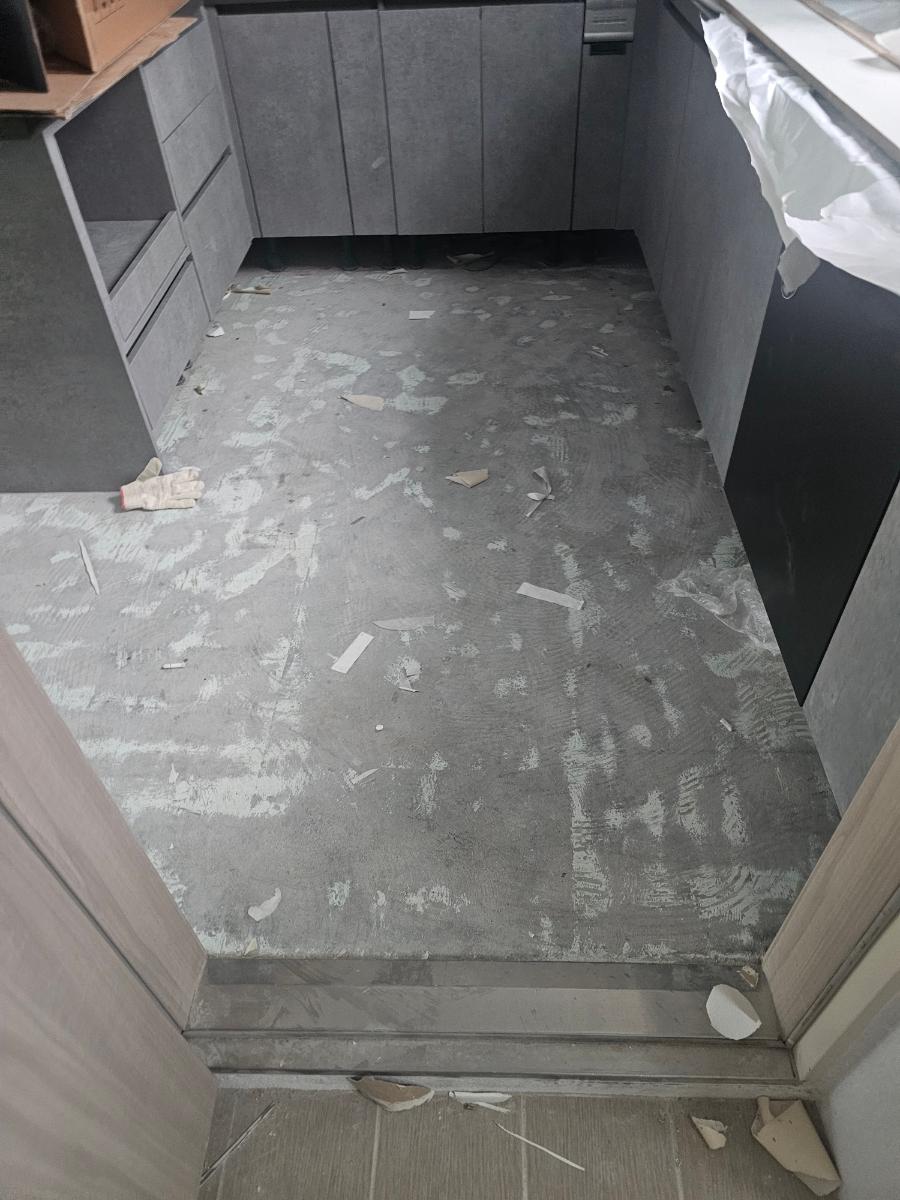 흰색 타일 바닥이 깔린 주방 내부의 공사 과정