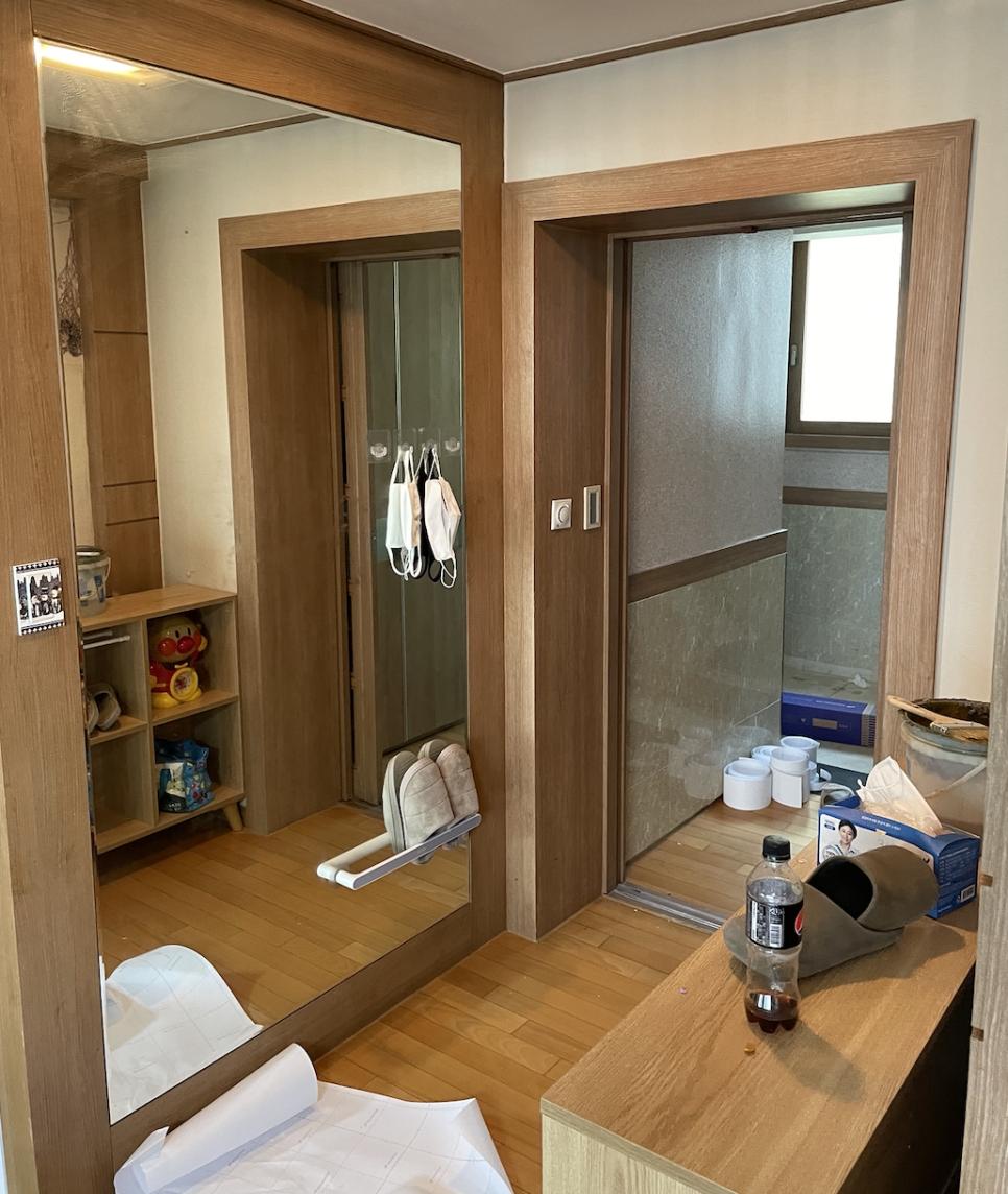 우드톤 벽면과 거울이 있는 현관 공간
