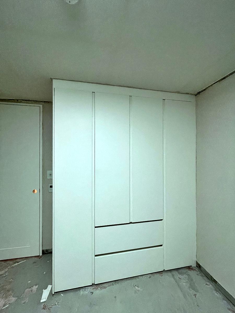 화이트 수납장이 배치된 정돈된 드레스룸 내부