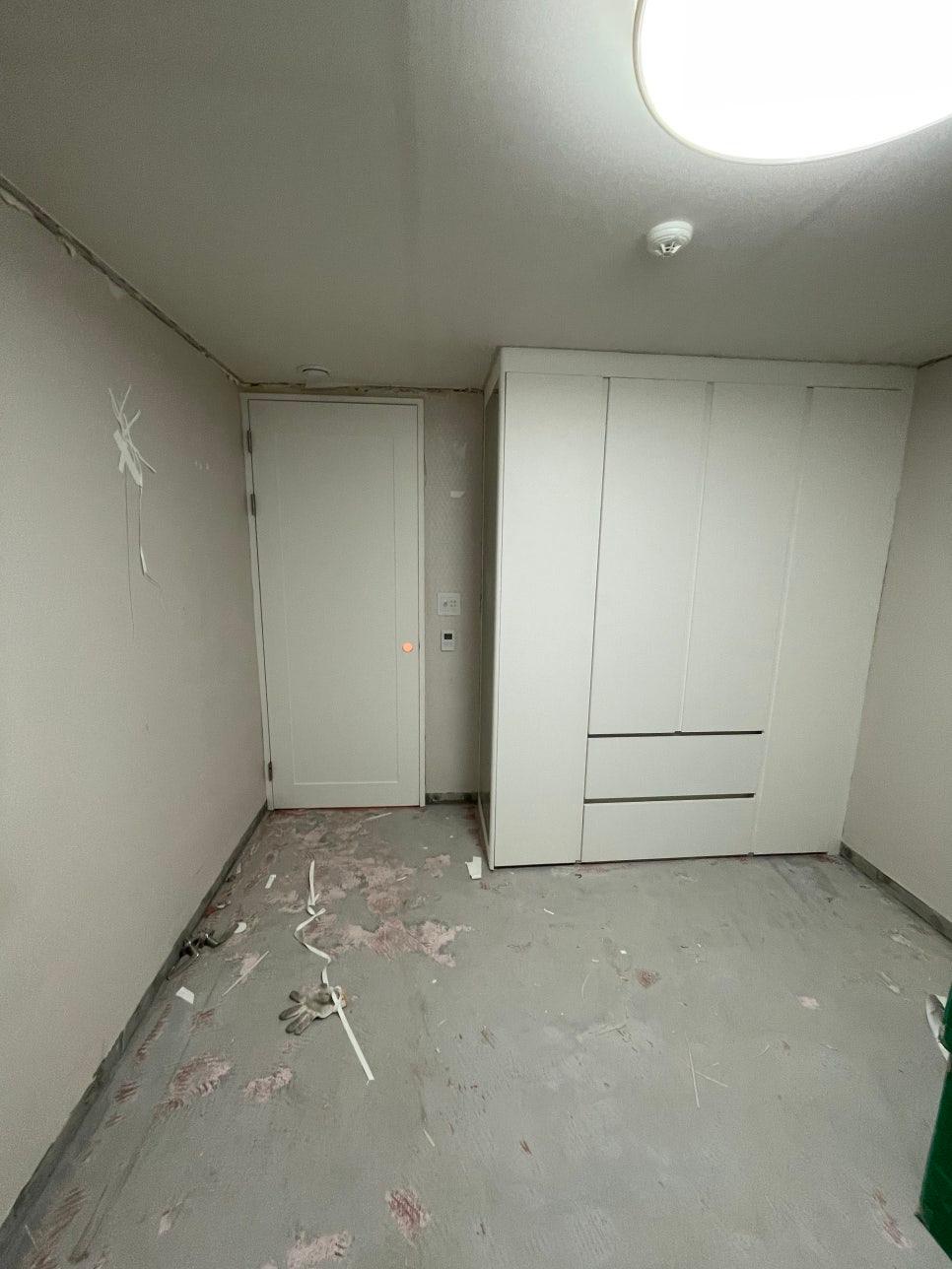 흰색 수납장과 문이 설치된 작업 중인 공간