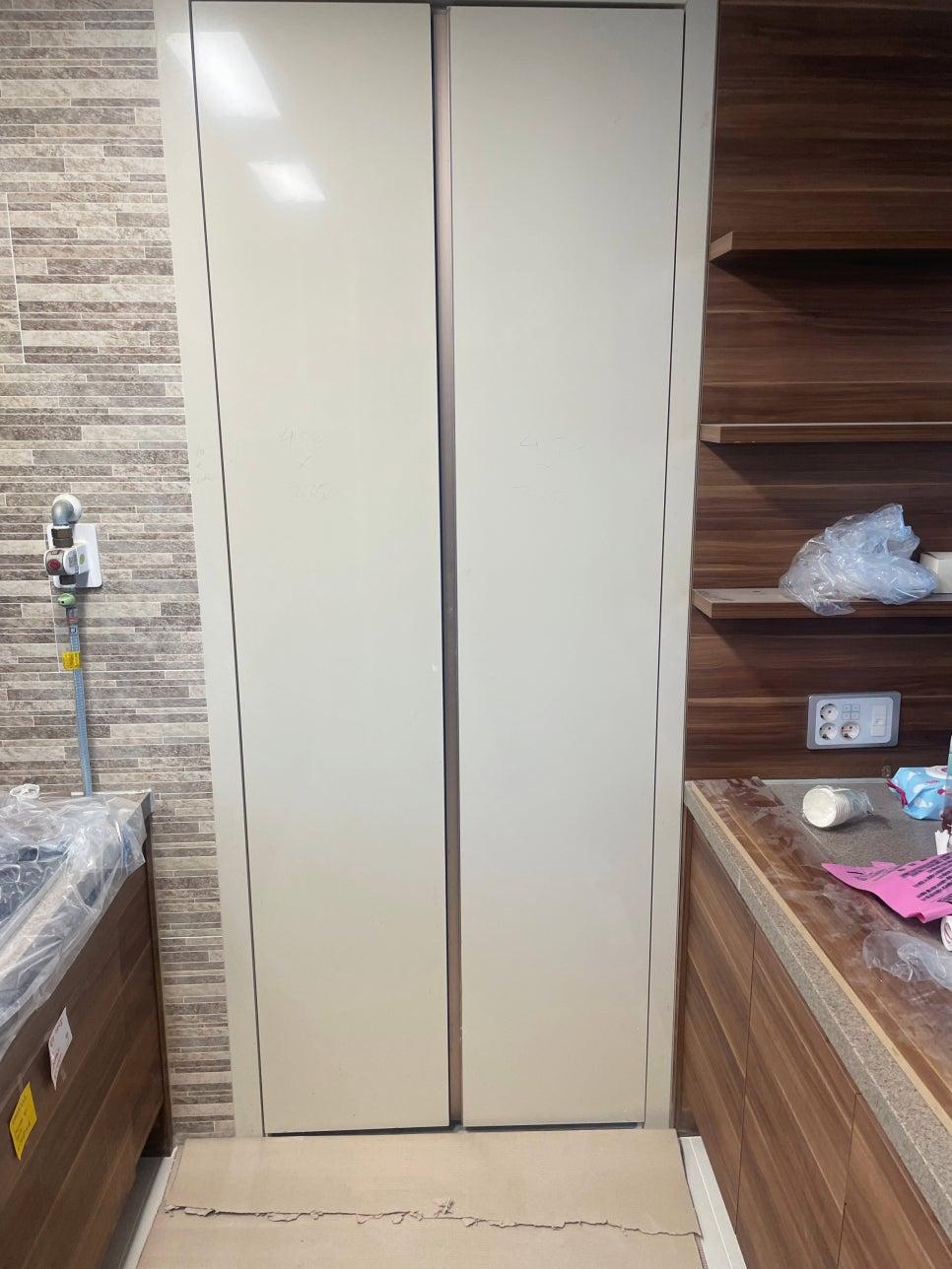 나무 톤 상판과 화이트 도어가 만나는 주방 공사 현장