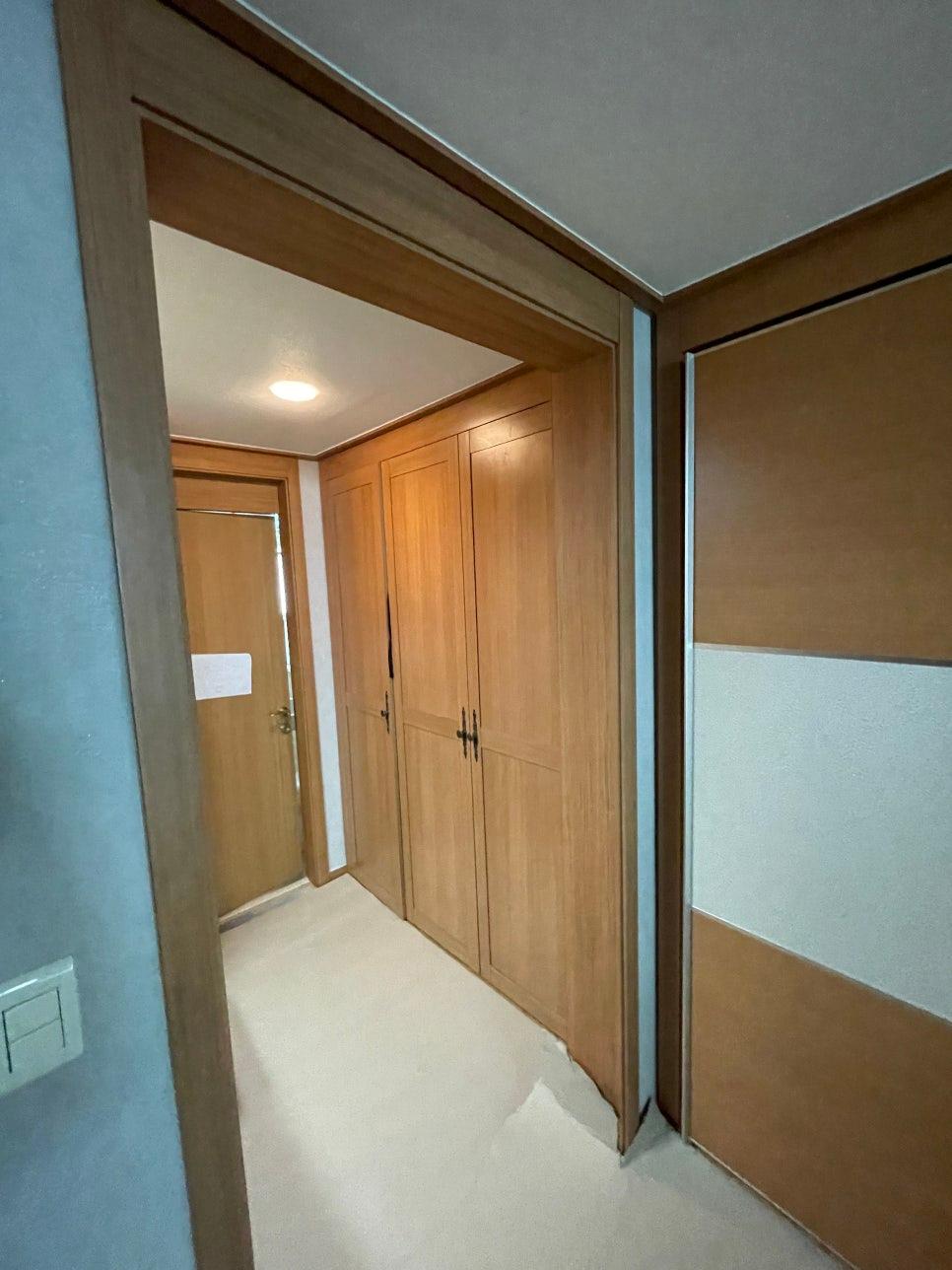 우드톤 벽면과 바닥재가 이어지는 복도 공간