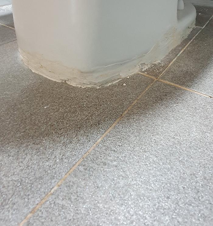 흰색 세면대 바닥 부분의 마감재와 주변 타일