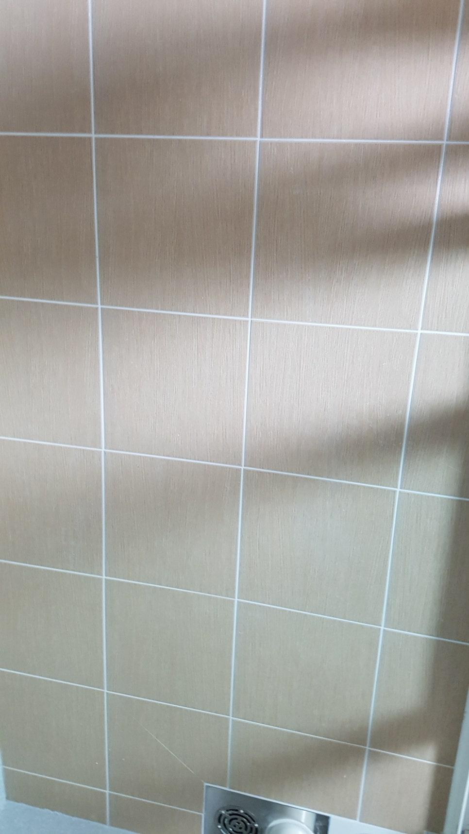 베이지색 타일 벽면과 배수구 주변 마감