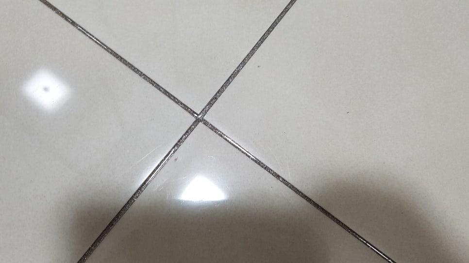 흰색 타일 바닥의 검은색 틈새 작업