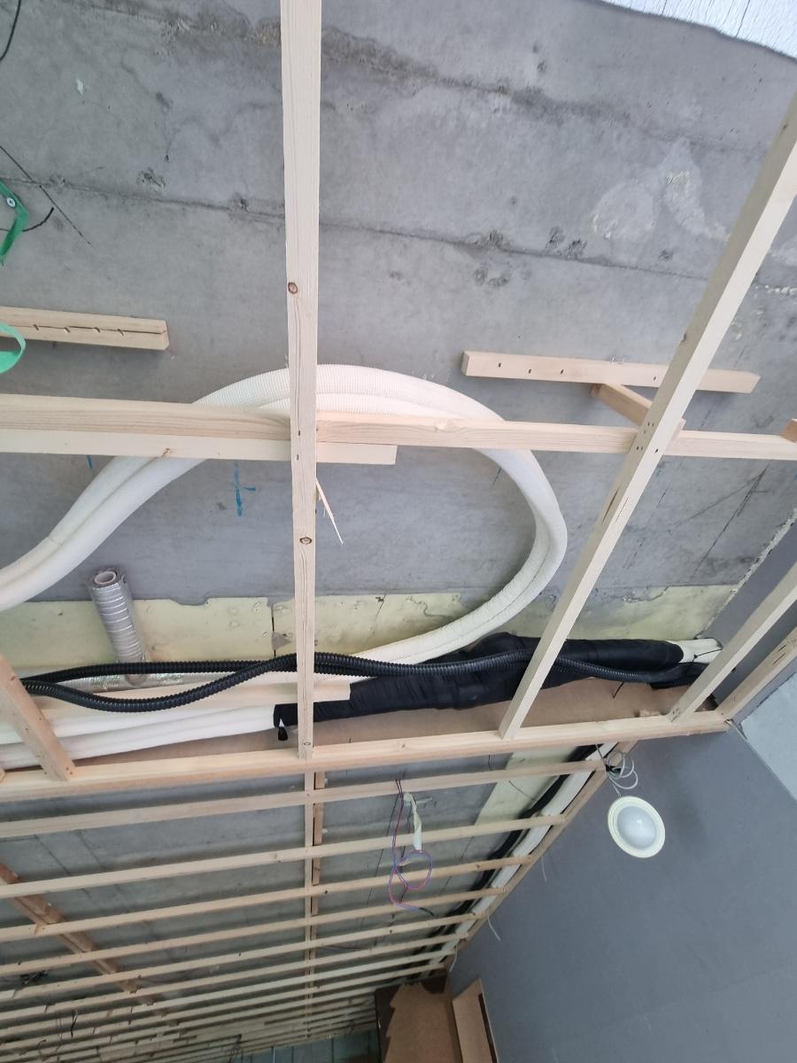 목재 프레임 구조물과 흰색·검정색 배관이 보이는 상태