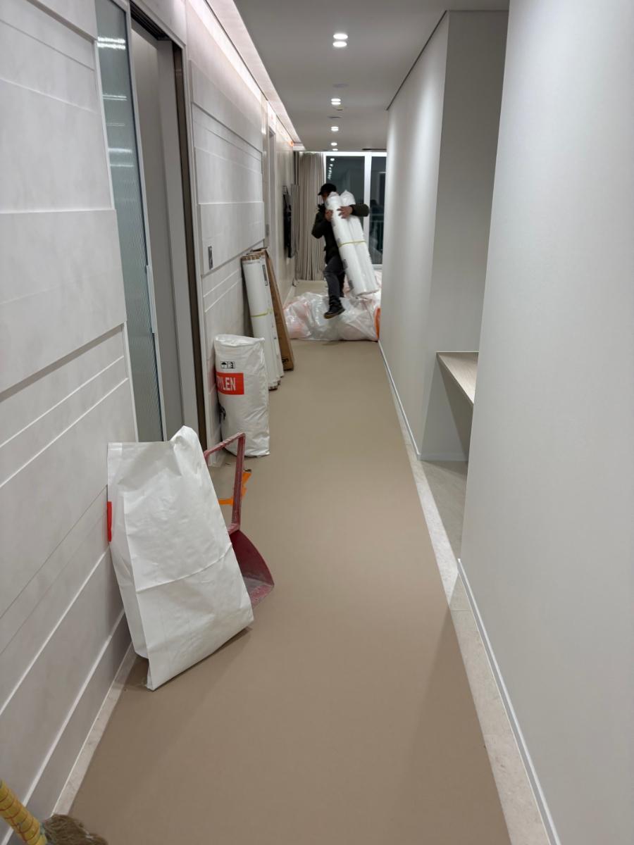 흰 벽과 베이지색 바닥이 보이는 복도 전경