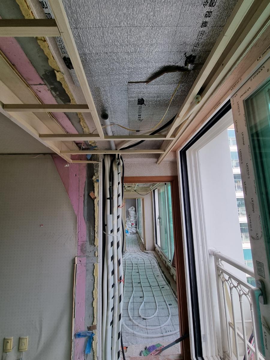 배관과 전선이 노출된 철거 벽면과 타일 바닥