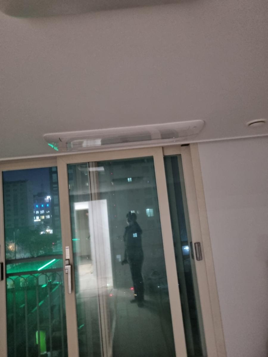 무광 화이트 마감 너머로 보이는 외부 건물과 조명