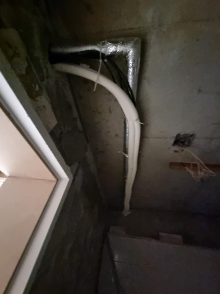 벽면에 고정된 알루미늄 보온재와 PVC 파이프