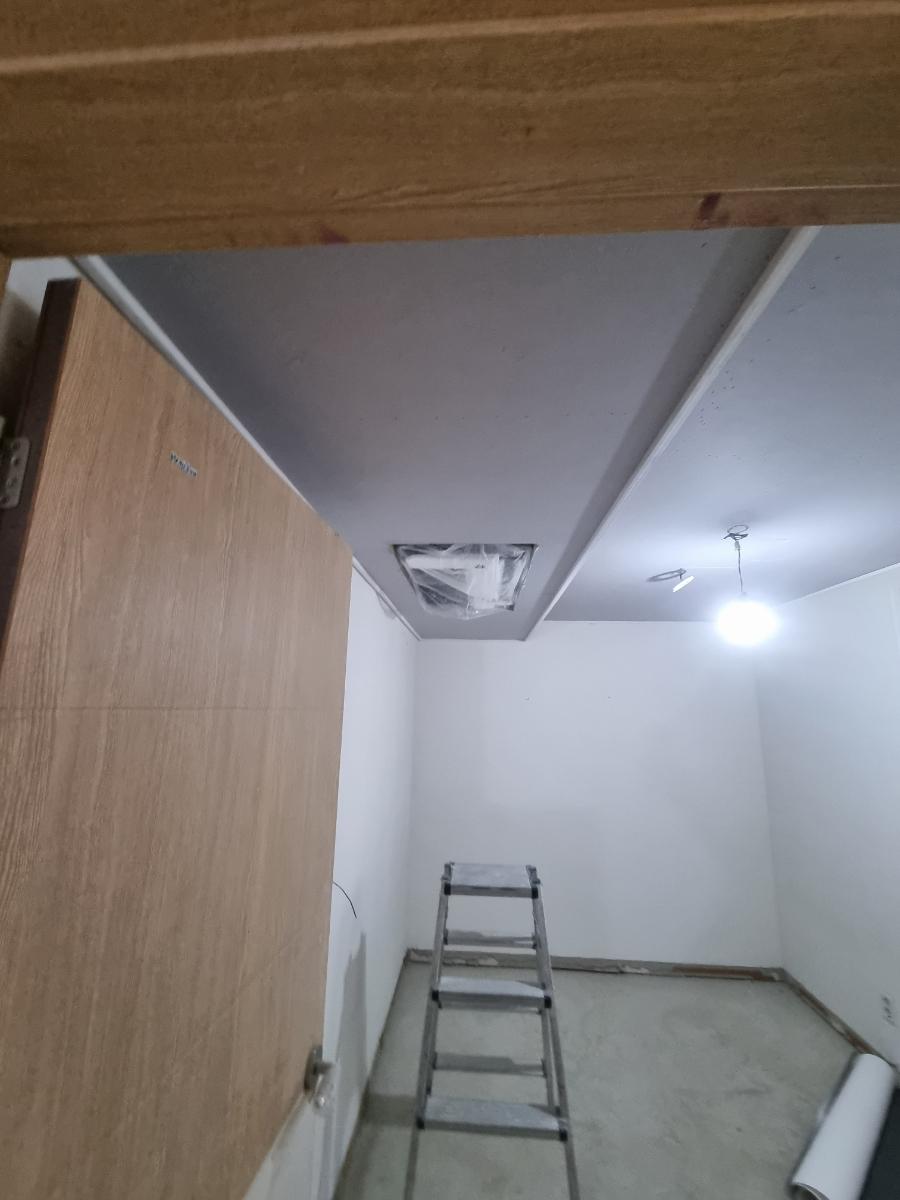 흰 벽과 천장 조명이 있는 빈 공간의 공사 모습