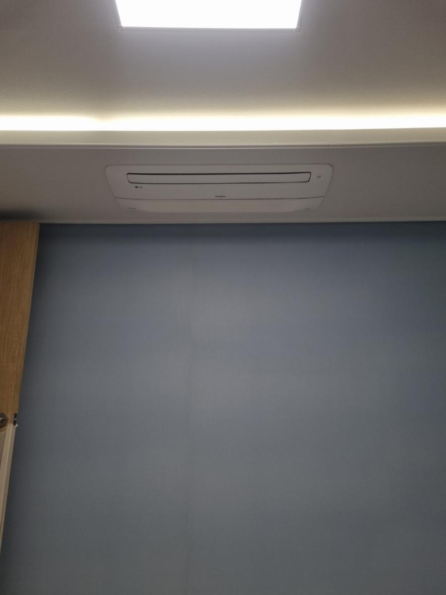 파란 벽면과 천장 에어컨, 조명이 어우러진 공간