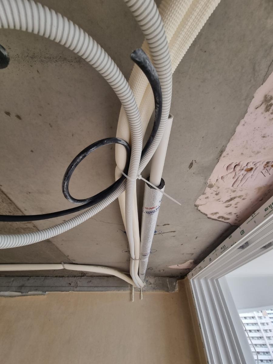 천장에 노출된 흰색 PVC 파이프와 검은색 전선
