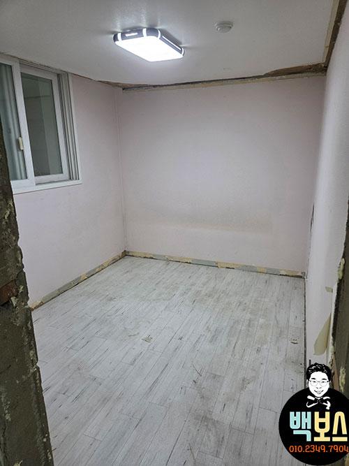 흰색 목재 바닥재와 흰 벽이 있는 빈 방의 모습