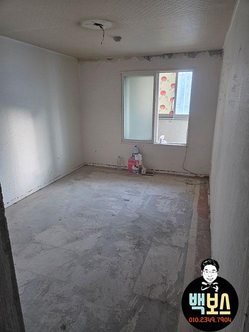 흰 벽과 흙바닥이 보이는 공사 중인 방