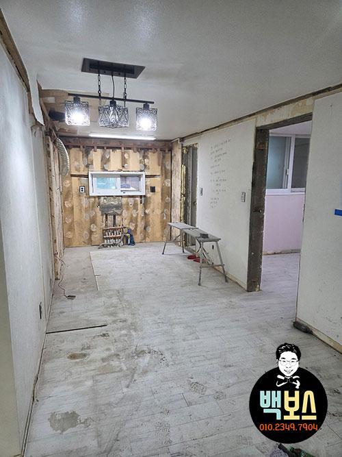 천장 조명과 문틀이 노출된 빈 복도 모습